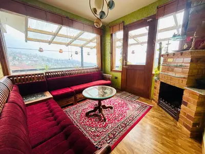 a living room with a red couch and a fireplace at Valley homes in Ooty