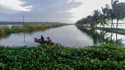 two men are riding a boat on a river at DB Apartment Arimpur in Trichūr