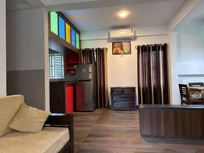a living room with a couch and a kitchen at DB Apartment Arimpur in Trichūr