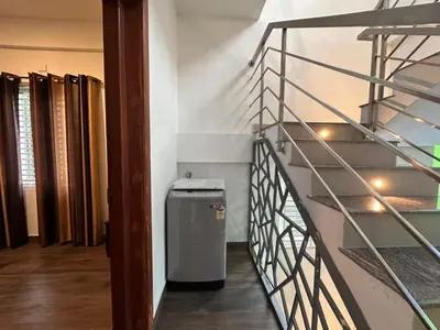 a hallway with a trash can next to a staircase at DB Apartment Arimpur in Trichūr