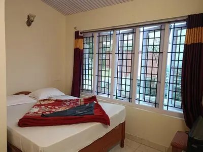 a bedroom with a bed with a red blanket on it at Abbu Royal Palace Cottage in Ooty