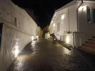 a motorcycle parked next to a building at night at Abbu Royal Palace Cottage in Ooty