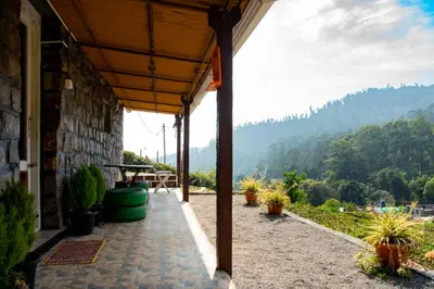a patio with a view of a mountain at Wild and Free Farm Stay in Ooty