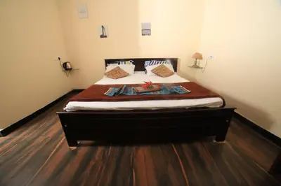 a large bed in a room with a wooden floor at Wild and Free Farm Stay in Ooty