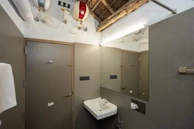 a bathroom with a sink and a mirror at Kudisai Marayoor - Munnar in Munnar