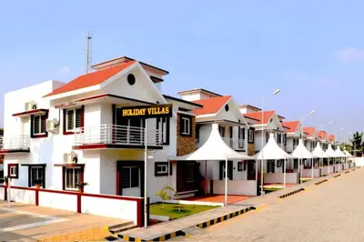 a row of white buildings with red roofs at Heritage Shelters Resort in Mysore