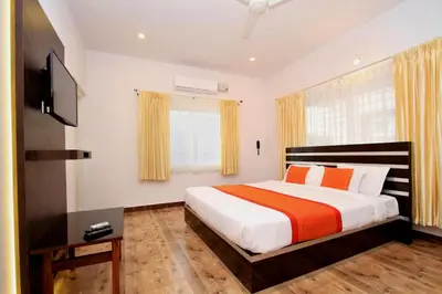 a bedroom with a bed and a flat screen tv at Heritage Shelters Resort in Mysore