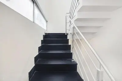 a staircase with black treads and white railings at Super Townhouse City Center Near Mysore Palace Formerly Aavass Inn in Mysore
