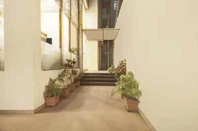 a hallway with potted plants and stairs in a building at Super Townhouse City Center Near Mysore Palace Formerly Aavass Inn in Mysore