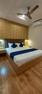 a bedroom with a large bed with blue pillows at Sky Inn in Mysore