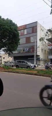 a car is parked in front of a building at Sky Inn in Mysore