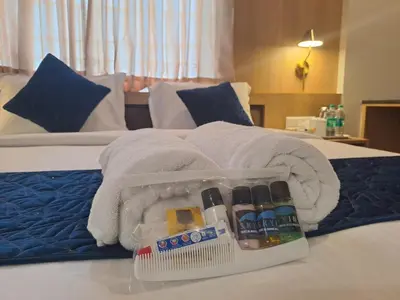 a hotel room with a towel on a bed at Sky Inn in Mysore