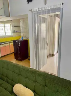 a living room with a green couch and a kitchen at Royal King Bed Suite, Service Apartments, 1km to center , Free WI-FI in Mysore