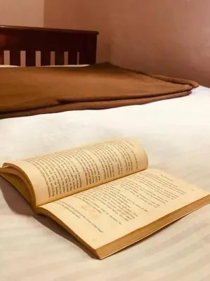 an open book sitting on top of a bed at Neermathalam, a traditional kerala tharavadu in Palakkad
