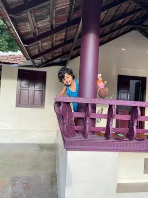 a woman is standing on a ride at a playground at Neermathalam, a traditional kerala tharavadu in Palakkad