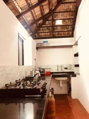 a kitchen with a stove top in a room at Neermathalam, a traditional kerala tharavadu in Palakkad