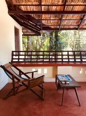 a bench and a table in a room with a balcony at Neermathalam, a traditional kerala tharavadu in Palakkad