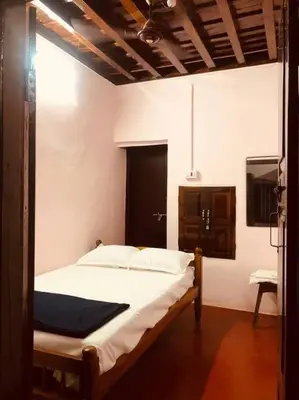 a bedroom with a bed and a television in it at Neermathalam, a traditional kerala tharavadu in Palakkad