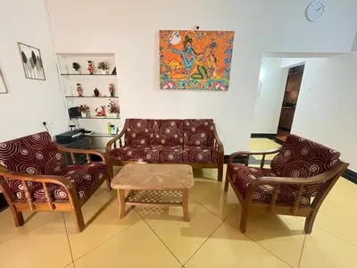 a living room with a couch and chairs and a table at Neha's Homestay in Mysore