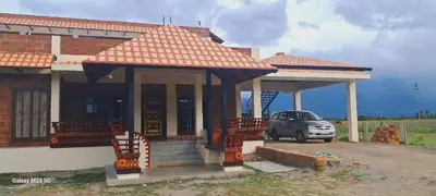 a house with a car parked in front of it at Lakshmi illam Near Isha Yoga Adiyogi in Alāndurai