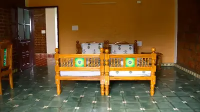 a pair of wooden beds in a room at Lakshmi illam Near Isha Yoga Adiyogi in Alāndurai