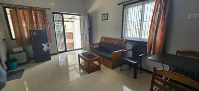 a living room with a couch and a piano at SHIs Spandha Apartments Near Coimbatore Airport in Coimbatore