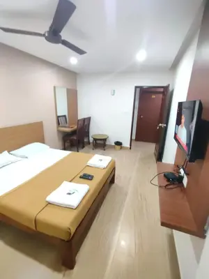a bedroom with a bed and a flat screen tv at Nandan Residency in Mysore