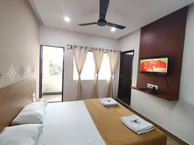 a bedroom with a bed and a ceiling fan at Nandan Residency in Mysore