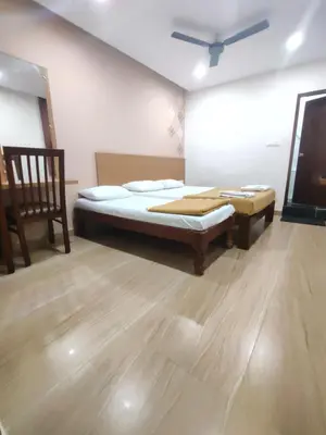 a room with a bed and a tv in it at Nandan Residency in Mysore
