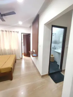 a living room with a bed and a mirror at Nandan Residency in Mysore