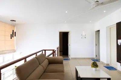 a living room with a couch and a table at Rosy Villa - Riverside Stay with Pool & View in Alwaye