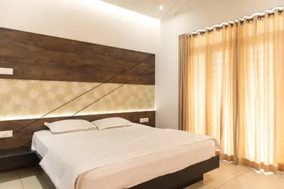 a bedroom with a large bed with a wooden headboard at Rosy Villa - Riverside Stay with Pool & View in Alwaye