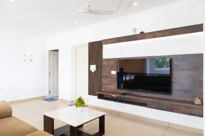 a living room with a flat screen tv on a wall at Rosy Villa - Riverside Stay with Pool & View in Alwaye
