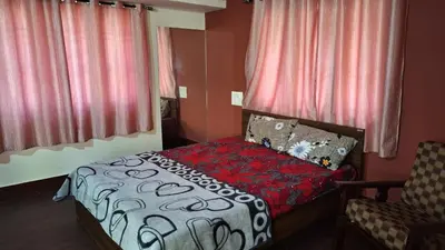 a small bedroom with a bed and a chair at Golden Nest Home Stay in Mysore