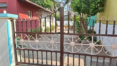 a iron fence with a gate in front of a street at Golden Nest Home Stay in Mysore