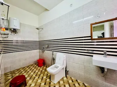 a bathroom with a toilet and a sink at Teyt's Green Haven - 3 BHK in Ooty