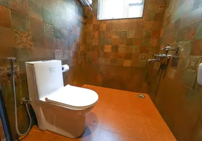 a bathroom with a toilet and a shower at Silent Retreat Ooty Pool Resort by VOYE HOMES in Ooty
