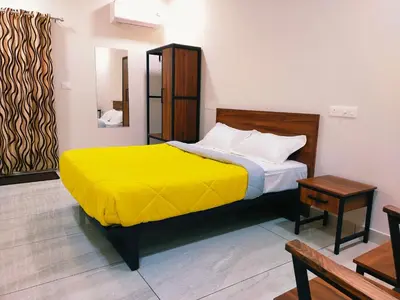 a bedroom with a bed with a yellow blanket at Bamboo Suite at Merlys Fruit Garden in Kotamangalam