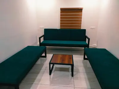 a green couch and a coffee table in a room at Bamboo Suite at Merlys Fruit Garden in Kotamangalam