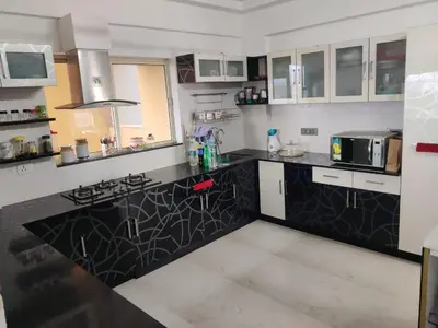 a kitchen with a black and white counter top at Urban Oasis in Trichūr