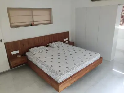a bedroom with a bed with a wooden headboard at Urban Oasis in Trichūr