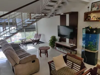 a living room with a couch and a flat screen tv at Urban Oasis in Trichūr