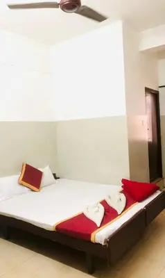 a bed with white sheets and a red blanket at Midtown Residency in Kozhikode