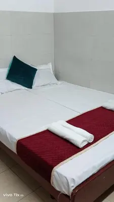 a bed with white sheets and towels on it at Midtown Residency in Kozhikode