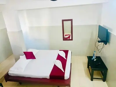 a bedroom with a bed with red and white pillows at Midtown Residency in Kozhikode