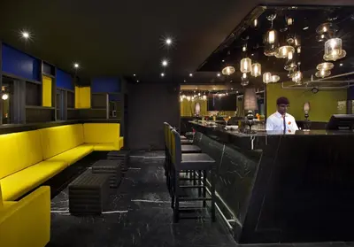 a man standing at a bar in a restaurant at Zone By The Park Coimbatore in Coimbatore