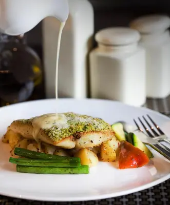 a plate of food with chicken and vegetables on a table at Zone By The Park Coimbatore in Coimbatore