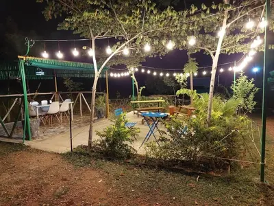 a patio at night with lights and a table at Wilderness Jungle Camp in Malavalli