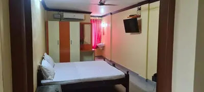 a small room with a bed and a mirror at Prestige Tourist Home in Nedumbassery
