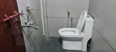 a bathroom with a toilet with the lid up at Prestige Tourist Home in Nedumbassery